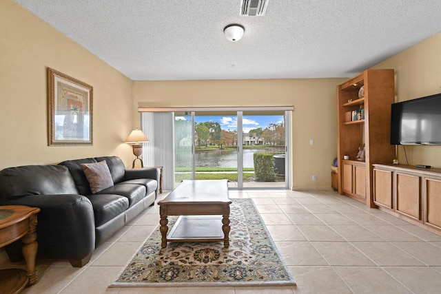 tiled living room featuring a textured ceiling