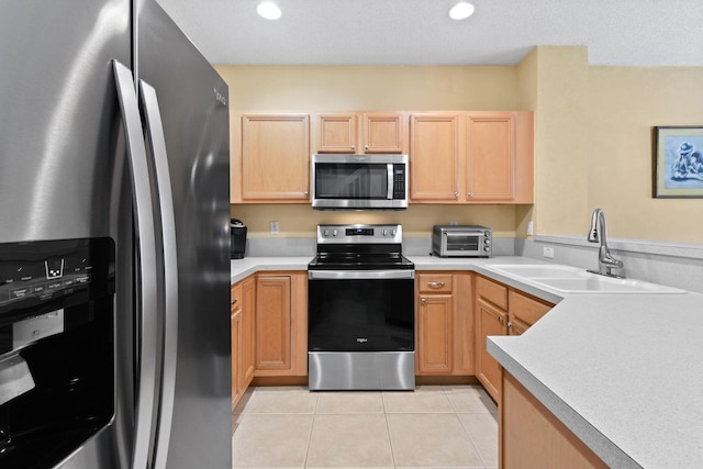 kitchen featuring light tile patterned floors, sink, light brown cabinetry, and appliances with stainless steel finishes