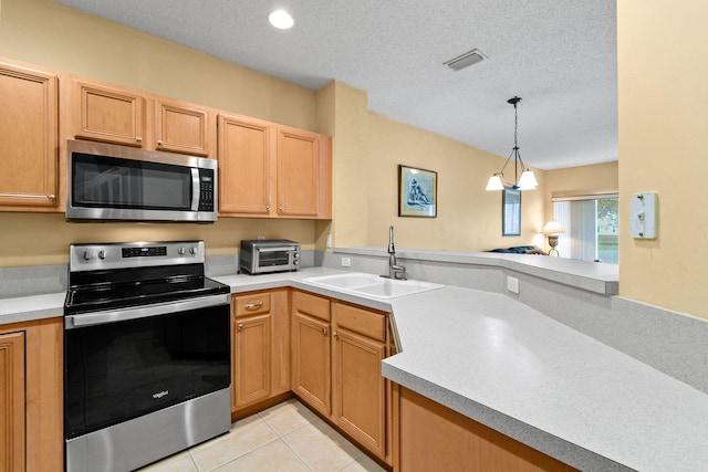 kitchen with pendant lighting, a textured ceiling, stainless steel appliances, sink, and light tile patterned floors