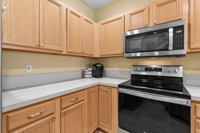 kitchen with electric range oven and light brown cabinets