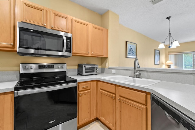 kitchen featuring pendant lighting, appliances with stainless steel finishes, sink, light tile patterned floors, and a textured ceiling