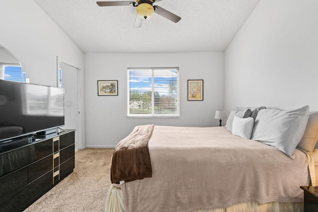 carpeted bedroom with ceiling fan and a textured ceiling