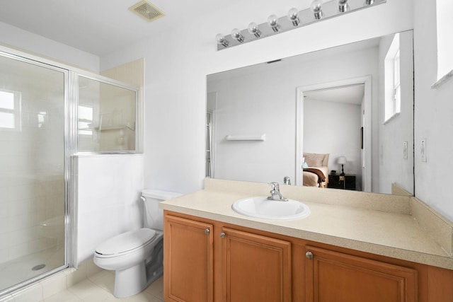 bathroom featuring vanity, toilet, a shower with door, and tile patterned flooring