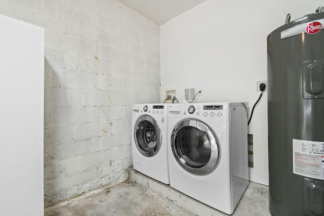 washroom featuring water heater and washing machine and clothes dryer