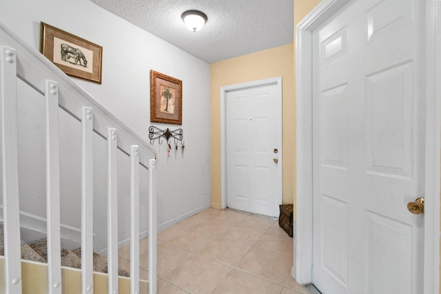 tiled entrance foyer with a textured ceiling