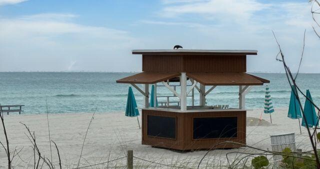 view of patio with a water view and a beach view