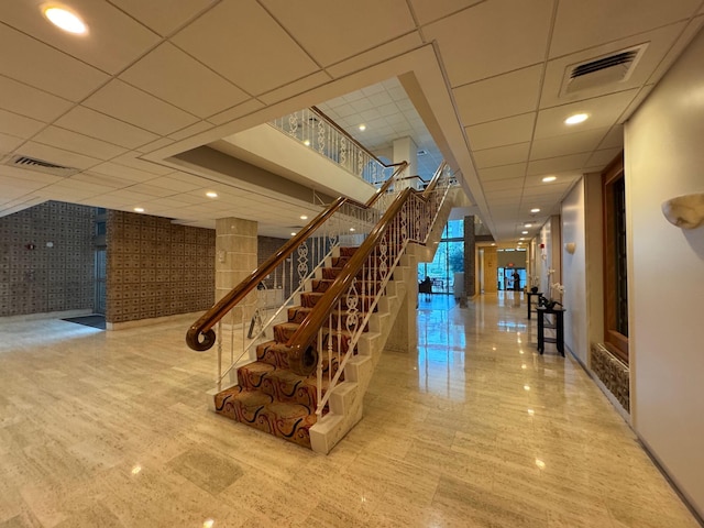 staircase with a paneled ceiling