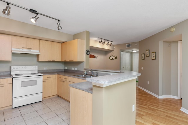 kitchen with white electric stove, sink, light tile patterned floors, kitchen peninsula, and light brown cabinets