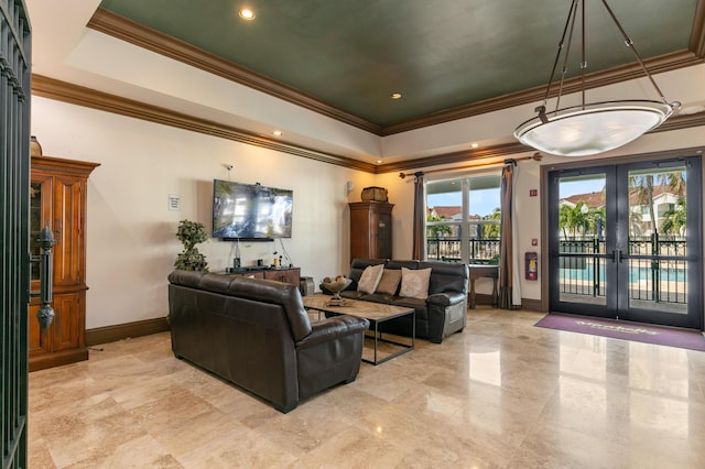 living room with french doors, ornamental molding, and a tray ceiling