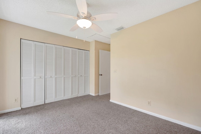 unfurnished bedroom featuring ceiling fan, carpet floors, a closet, and a textured ceiling