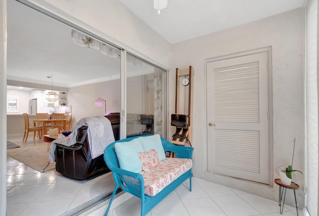 sitting room with light tile patterned floors and ornamental molding