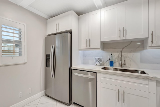 kitchen with sink, white cabinets, light tile patterned floors, light stone counters, and stainless steel appliances