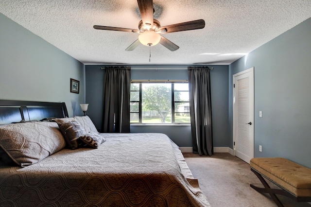 carpeted bedroom featuring a textured ceiling and ceiling fan