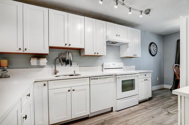 kitchen featuring white appliances, white cabinetry, sink, premium range hood, and light hardwood / wood-style flooring