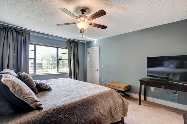 carpeted bedroom featuring a textured ceiling and ceiling fan