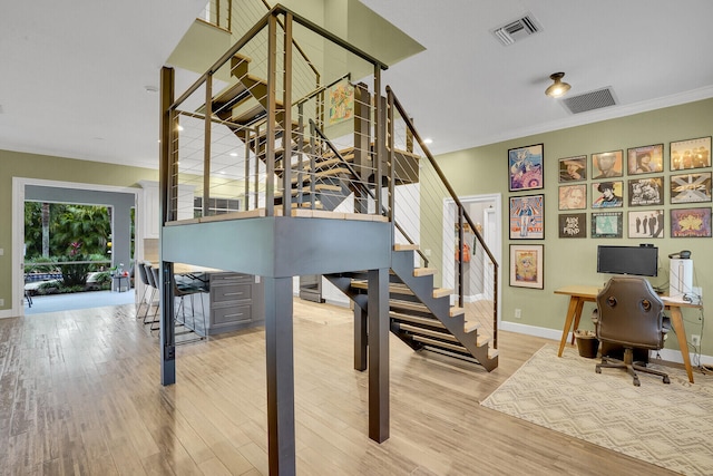 living room featuring crown molding, light wood-type flooring, ceiling fan, and ornate columns