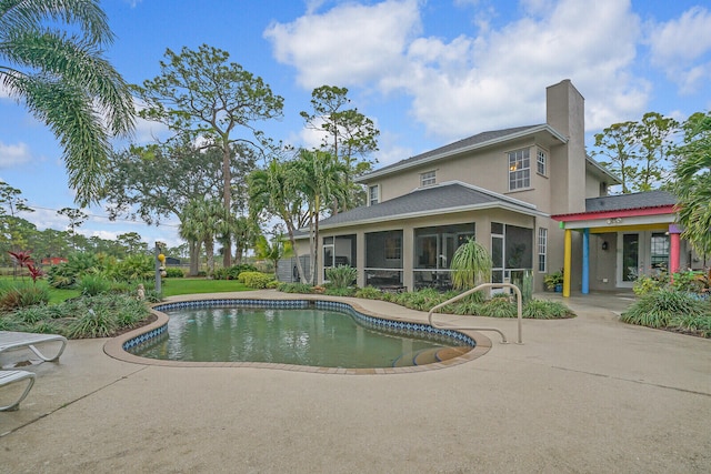 view of swimming pool featuring a patio and a sunroom