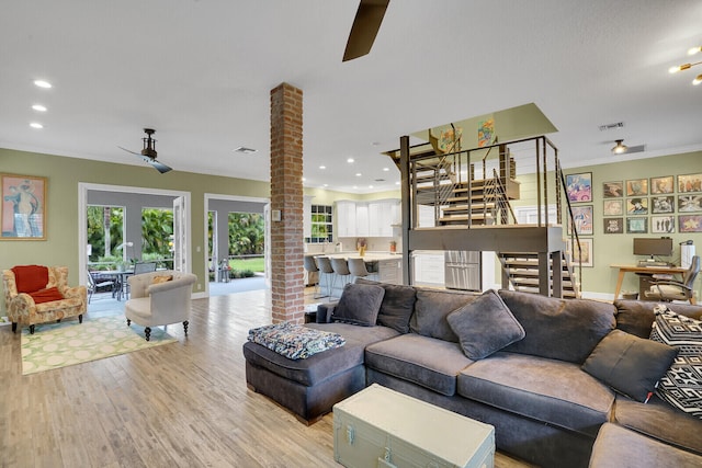 kitchen featuring wall chimney range hood, white cabinets, stainless steel appliances, and a kitchen island