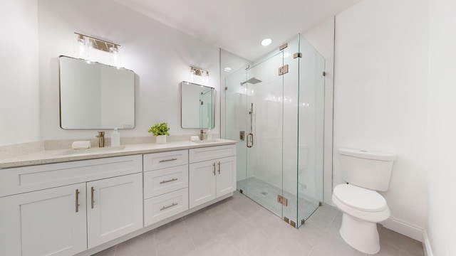 bathroom with tile patterned floors, toilet, vanity, and an enclosed shower