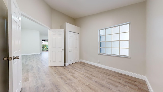 unfurnished bedroom featuring light hardwood / wood-style floors and a closet