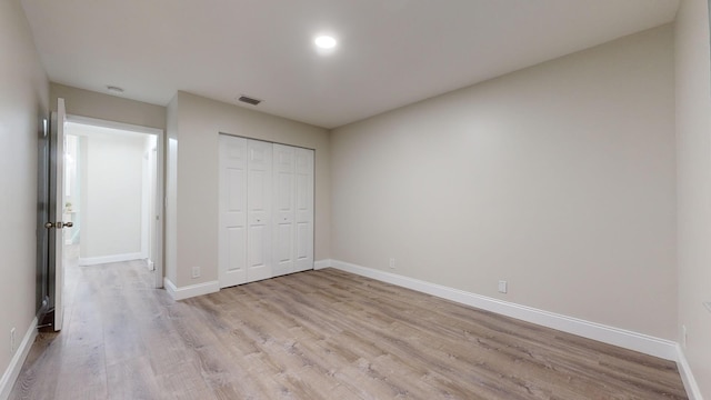 unfurnished bedroom with a closet and light wood-type flooring