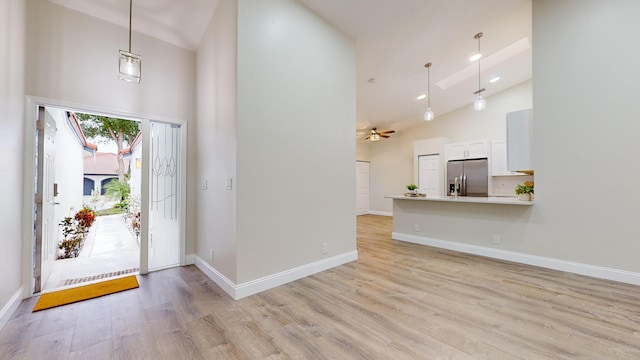 foyer featuring ceiling fan, high vaulted ceiling, and light hardwood / wood-style floors