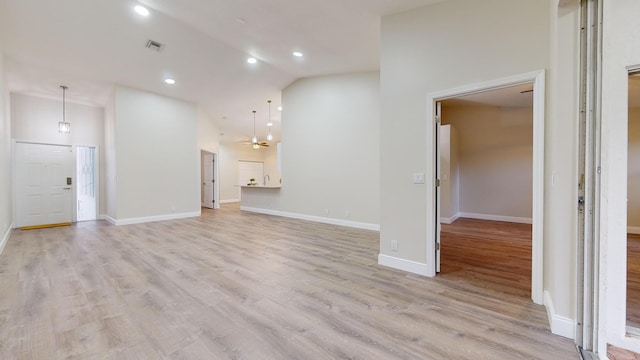 unfurnished living room featuring high vaulted ceiling and light wood-type flooring