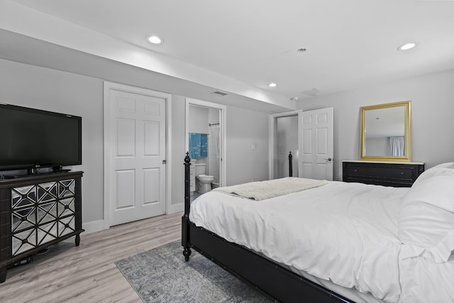 bedroom with ensuite bathroom and light hardwood / wood-style floors