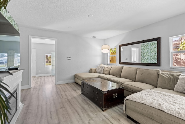 living room with light hardwood / wood-style flooring and a textured ceiling