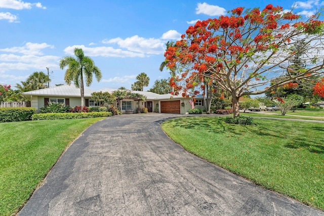 ranch-style house featuring a garage and a front lawn