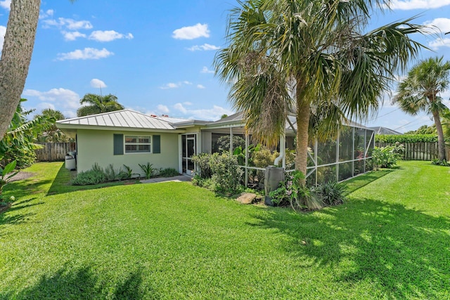 view of front of home with glass enclosure and a front yard