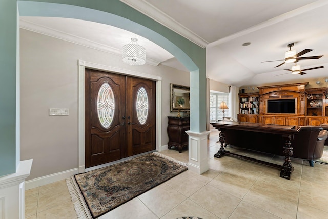 tiled foyer featuring ceiling fan with notable chandelier, crown molding, and lofted ceiling