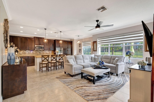 living room with crown molding, ceiling fan, and light tile patterned floors