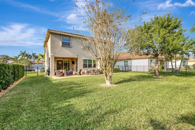 rear view of property with ceiling fan, a patio, and a lawn