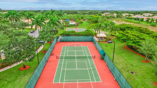 view of sport court with a lawn