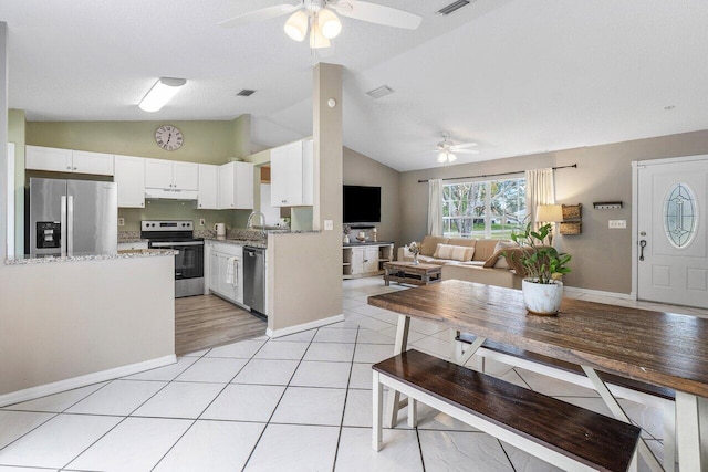 kitchen with vaulted ceiling, white cabinetry, and appliances with stainless steel finishes