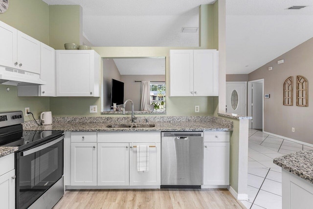 kitchen featuring sink, light stone counters, white cabinets, and appliances with stainless steel finishes