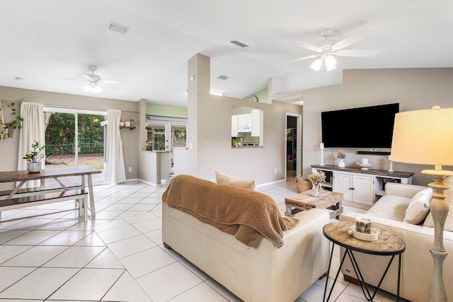 tiled living room with ceiling fan, a textured ceiling, and vaulted ceiling