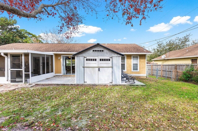 back of house featuring a patio, a yard, and a sunroom