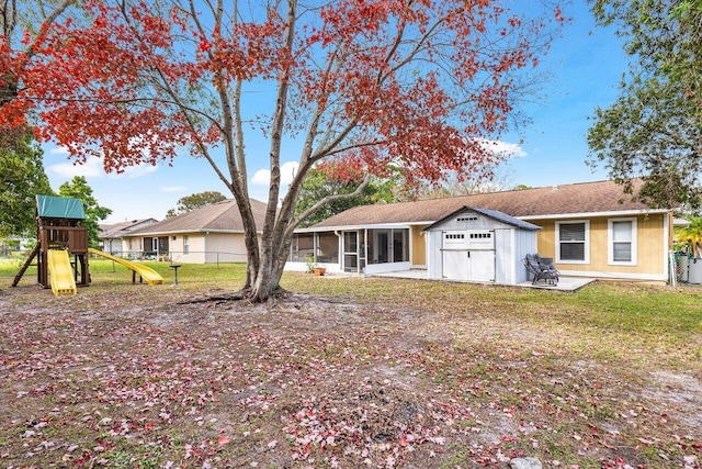 view of front of house featuring a sunroom, a patio area, a front yard, and a playground