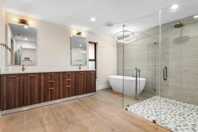 bathroom featuring vanity, wood-type flooring, and plus walk in shower