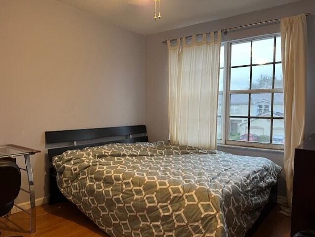 bedroom featuring dark hardwood / wood-style flooring and multiple windows