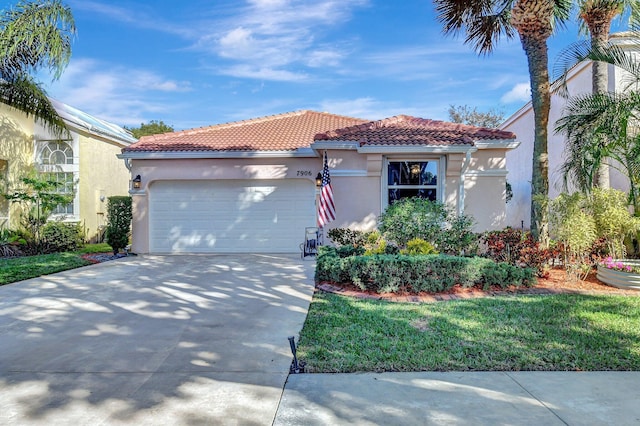 mediterranean / spanish home featuring a garage and a front lawn