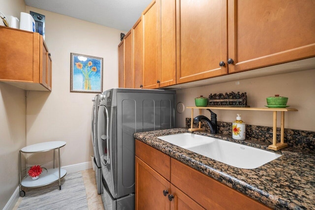 washroom featuring cabinets, sink, and washing machine and dryer