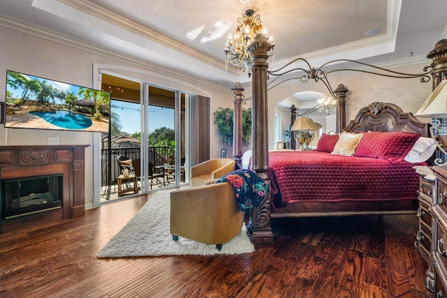 bedroom featuring an inviting chandelier, wood-type flooring, access to exterior, and a raised ceiling