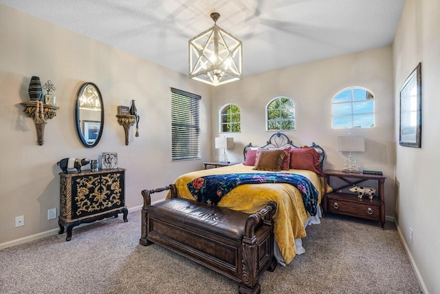 carpeted bedroom with an inviting chandelier and a textured ceiling