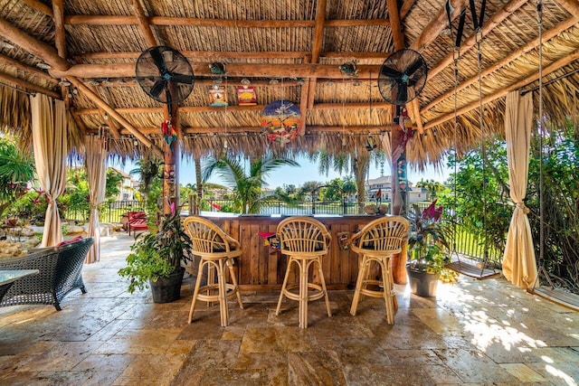 view of patio / terrace with a gazebo, ceiling fan, and a bar