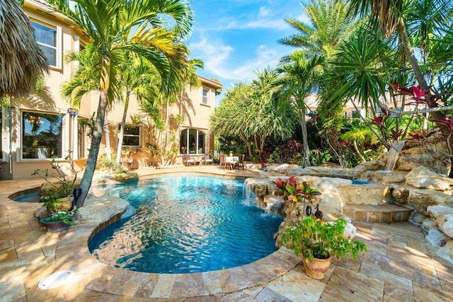 view of swimming pool featuring pool water feature and a patio