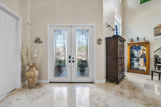 entrance foyer featuring a towering ceiling and french doors