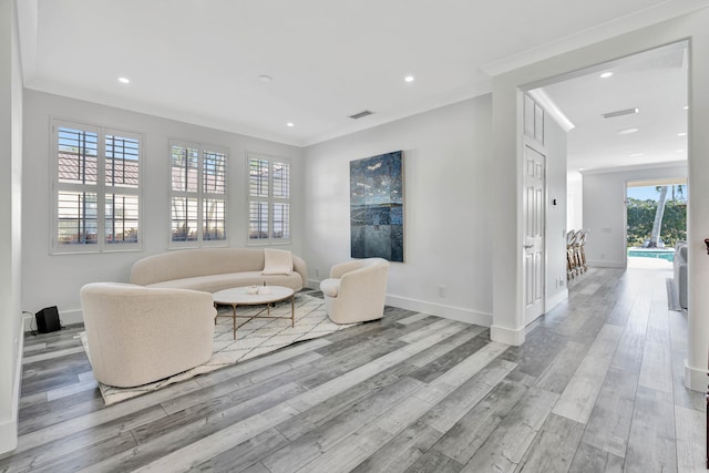 living room featuring crown molding and light hardwood / wood-style flooring